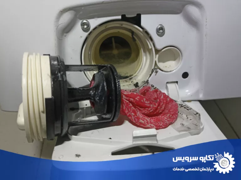 علت تخلیه نشدن آب در ماشین لباسشویی. انسداد و مسدودی فیلتر ماشین لباسشویی توسط لباس کوچک و پرز لباس از نمای نزدیک